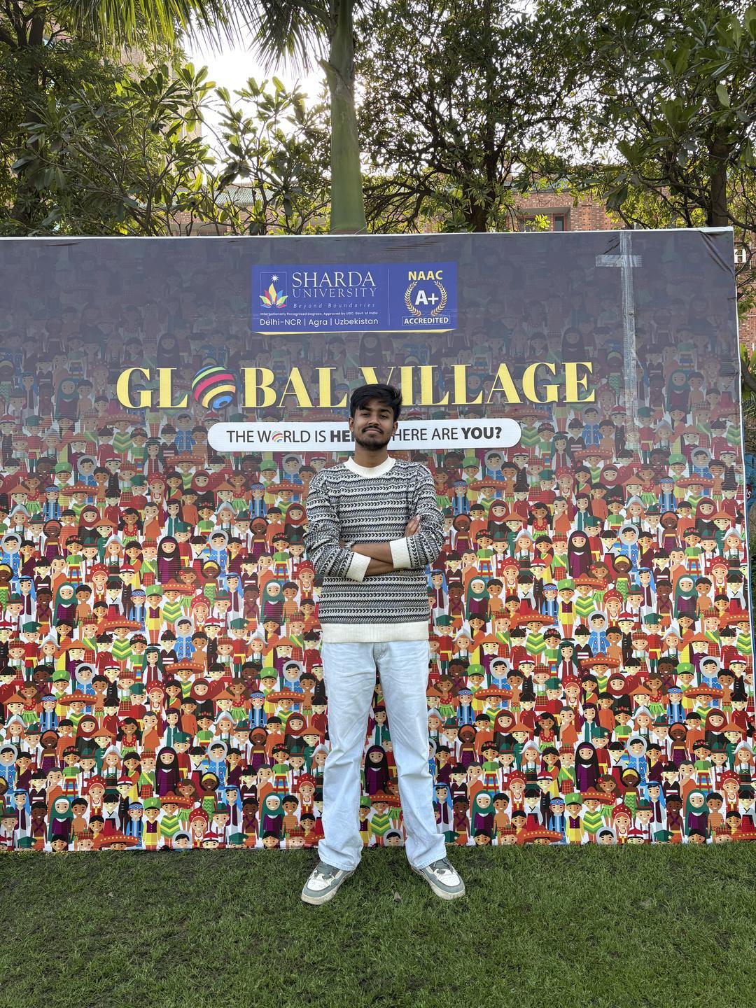 Sharda University-র Global Village ব্যানারের সামনে মৃণাল দাস