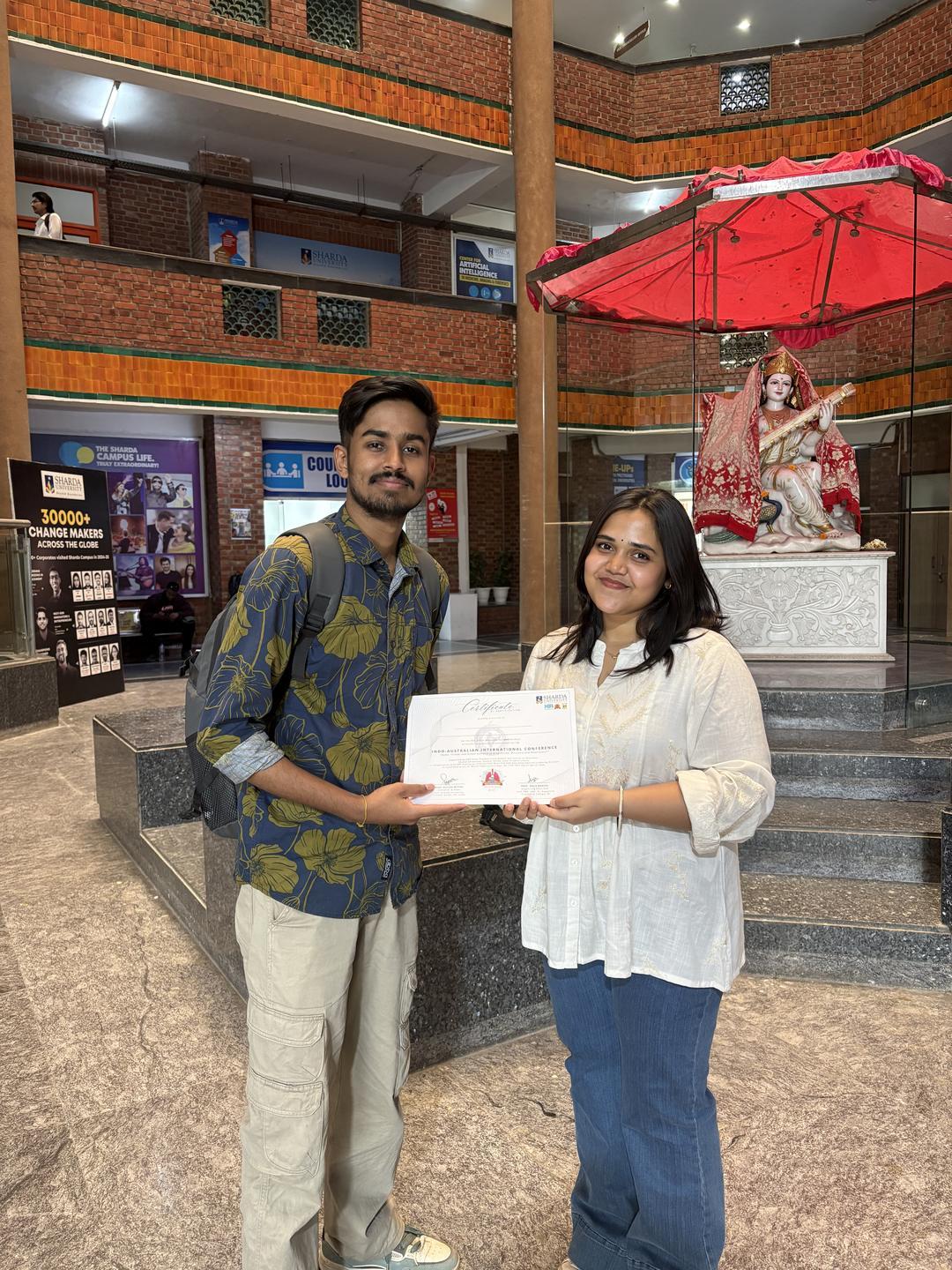 একটা ভবনের ভেতরে সার্টিফিকেট হাতে মৃণাল দাস
